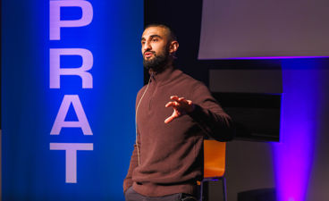 en person som står foran en skjerm med hendene utstrakt