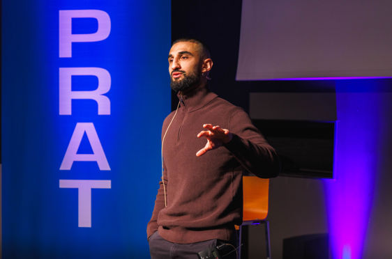 en person som står foran en skjerm med hendene utstrakt