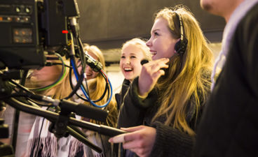 En person som snakker til en gruppe mennesker med hodetelefoner