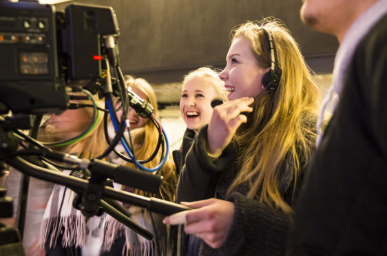 En person som snakker til en gruppe mennesker med hodetelefoner