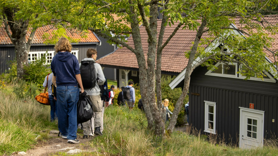 en gruppe mennesker som går på en sti ved siden av en bygning