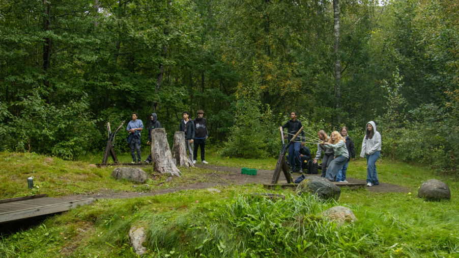 en gruppe mennesker som står på en bro over en bekk
