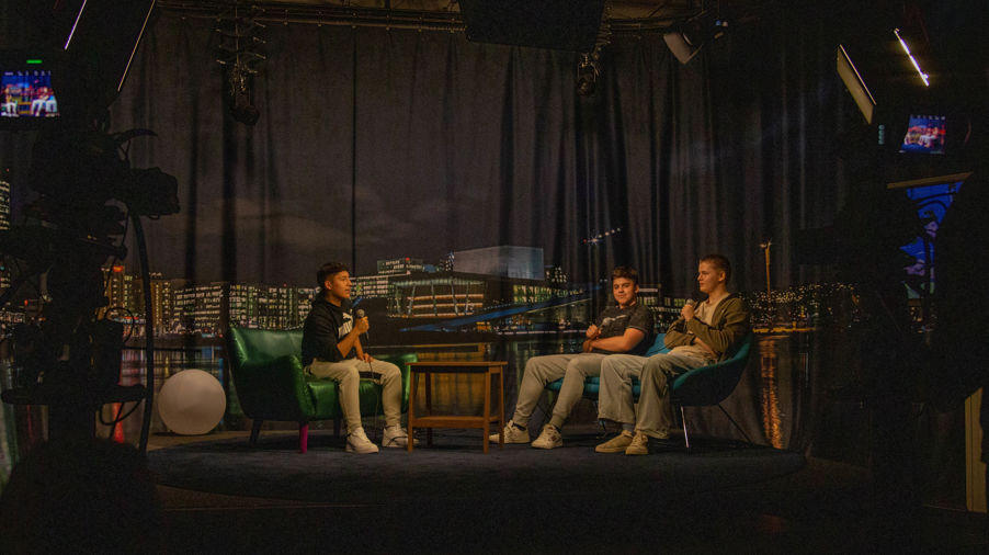 en gruppe menn som sitter på grønne stoler og spiller instrumenter