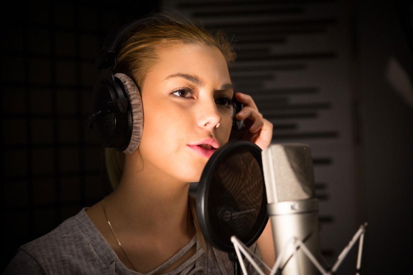 Jente under innspilling i lydstudio