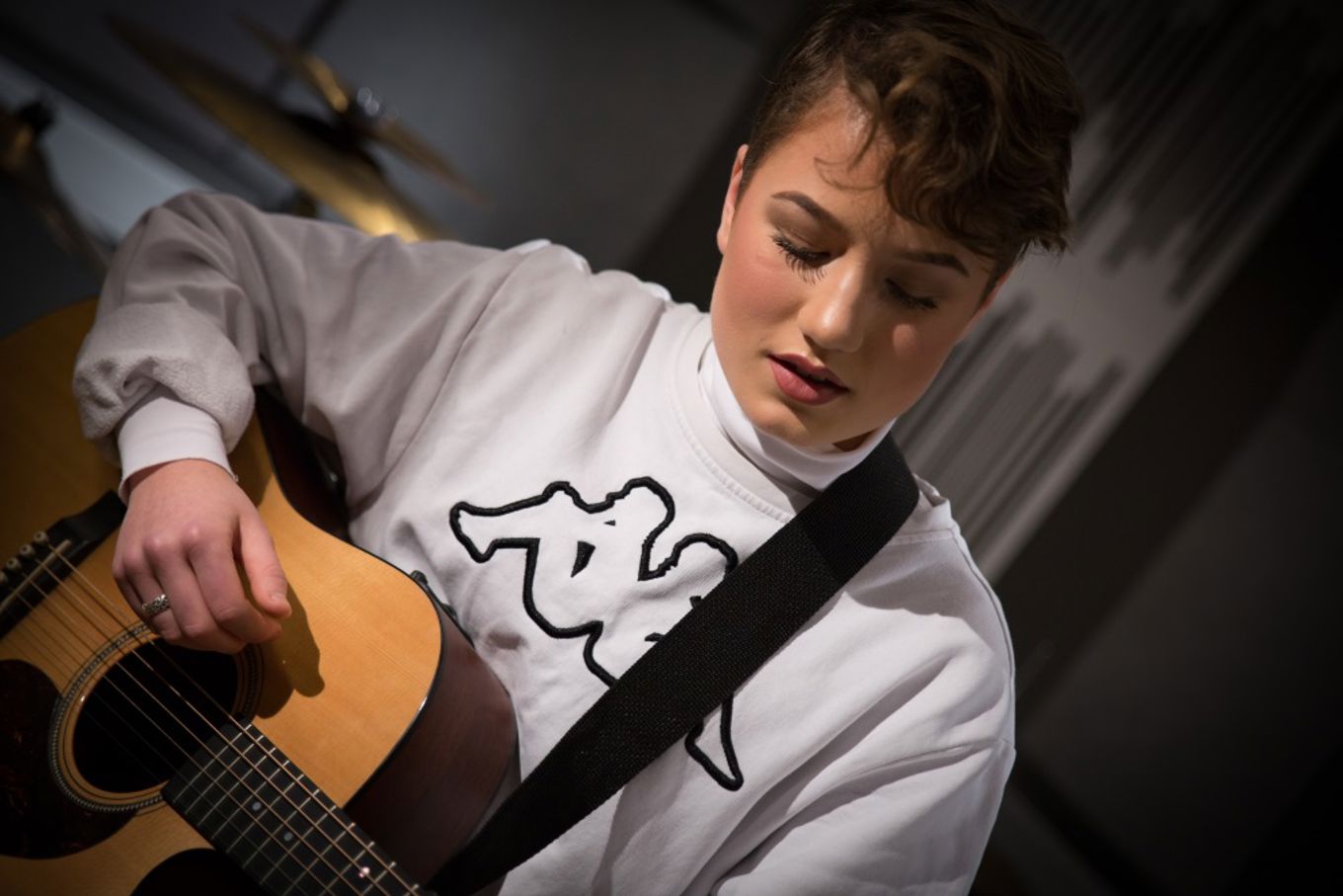 Jente spiller guitar i studio2